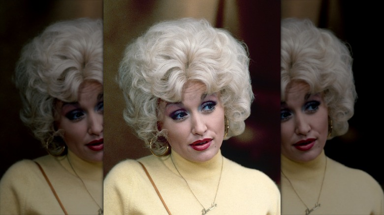 Dolly Parton portant une perruque blonde bouffante et du rouge à lèvres