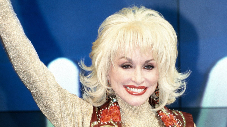 Dolly Parton portant un gilet marron et une coiffure au carré
