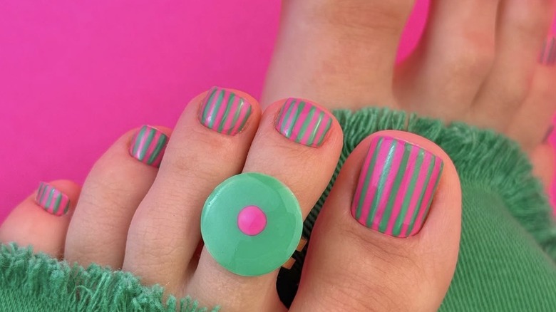 Pédicure rayée turquoise et rose vif