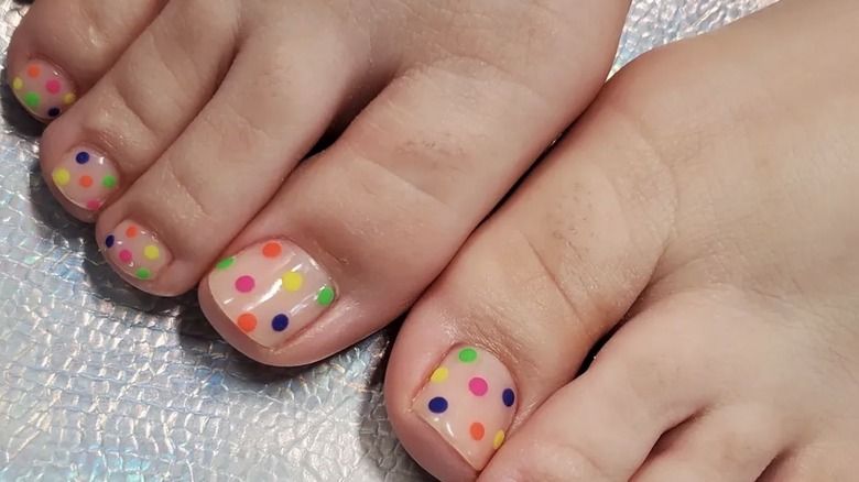 Pédicure à pois avec des pois roses, verts, bleu marine, orange et jaune.