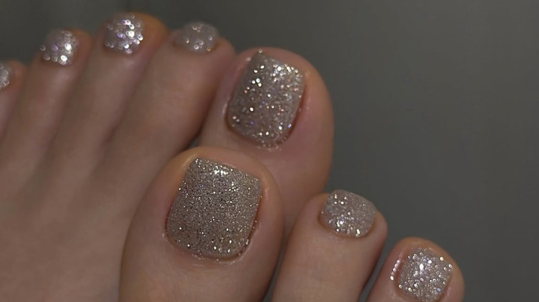 Pédicure à grosses paillettes argentées