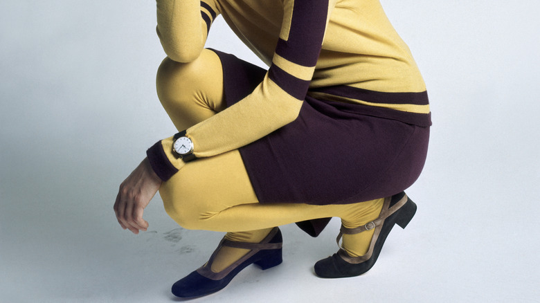 Gros plan sur les jambes d'une femme portant des collants jaunes et une robe jaune et violette