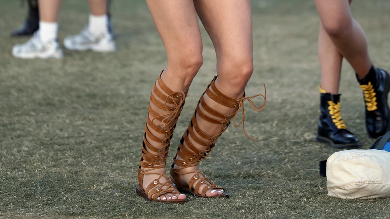 Gros plan sur une femme portant des sandales gladiateur à lacets marron