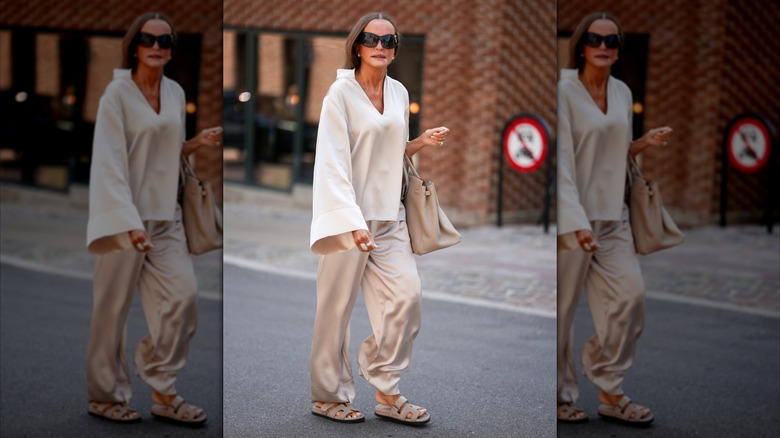 Une femme portant un pantalon en satin gris clair.