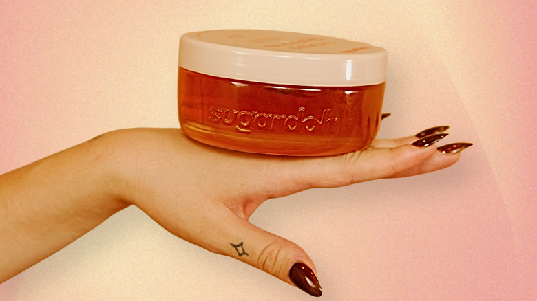 Un pot de Sugardoh's "Gros Doh" assis sur la main d'un mannequin