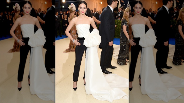 Emmy Rossum assiste au Met Gala 2017 avec un pantalon tailleur noir et un haut bustier blanc avec une traîne