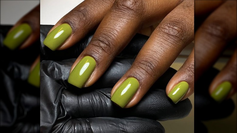 Une manucure courte avec du vernis vert olive