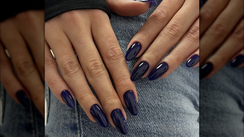 Une manucure en amande avec du vernis bleu nuit