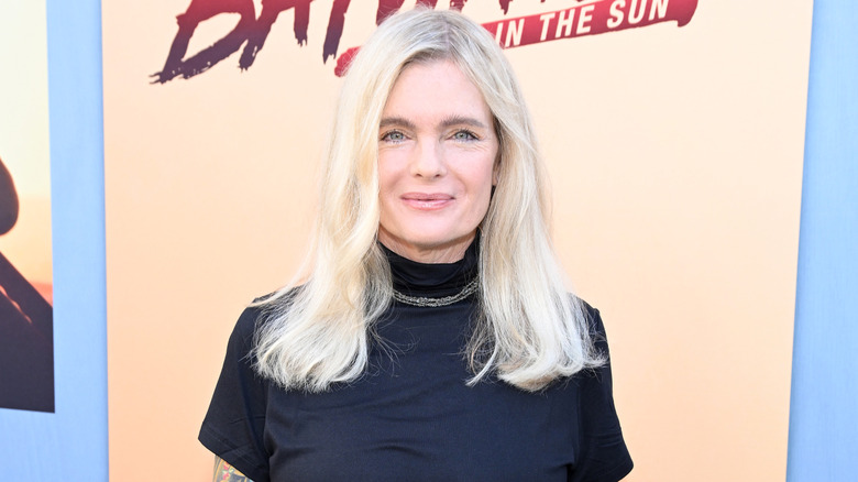 Erika Eleniak lors d'un événement en 2024 portant un haut à col roulé noir avec un simple collier.