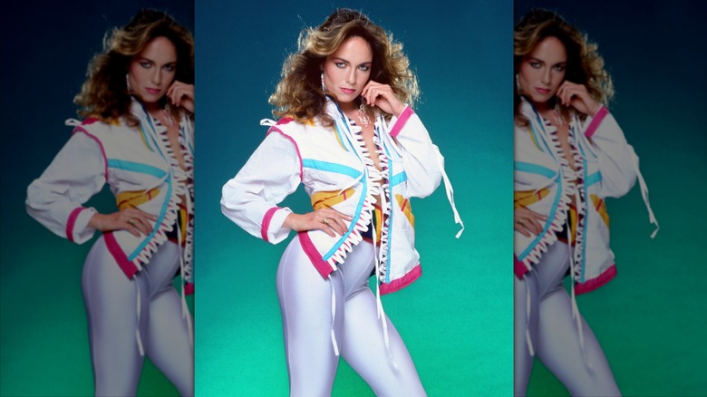 Catherine Bach pose avec des leggings blancs brillants et un bomber fluo