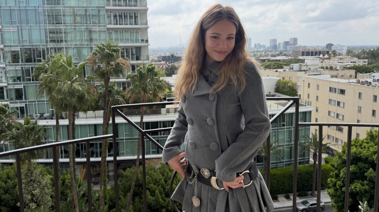 Skywalker Hughes posant dans un caban gris sur un balcon