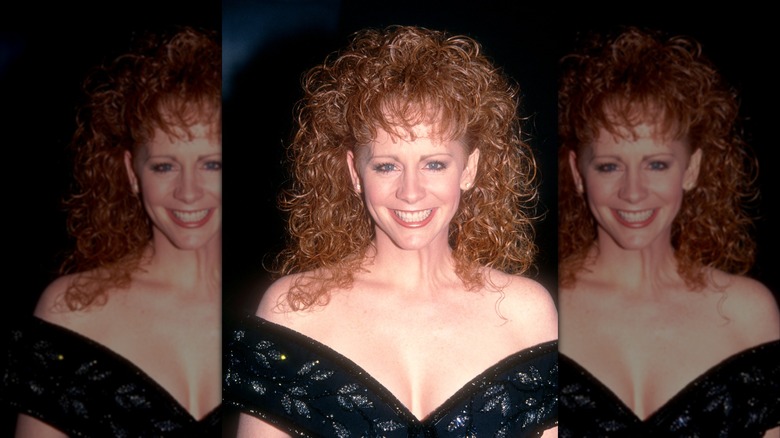 Reba McEntire dans une robe noire à épaules dénudées avec des cheveux bouclés définis lors des People's Choice Awards de 1992.