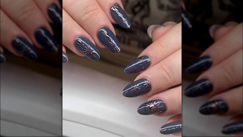 Manucure ronde avec vernis à ongles gris-bleu et motifs célestes