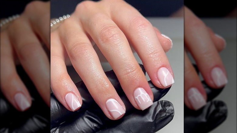 Manucure carrée courte avec symbole Vierge peint en blanc
