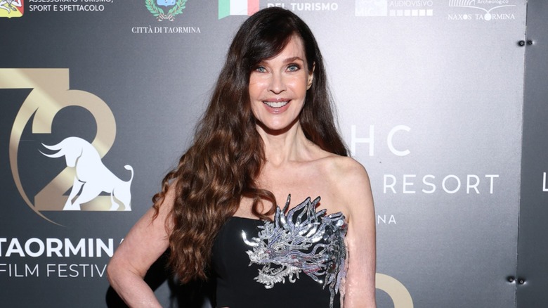 Carol Alt pose dans une robe bustier noire avec des ornements argentés avec ses longs cheveux bruns en boucles lâches alors qu'elle assistait au 72e Festival du film de Taormina en Italie en 2026.