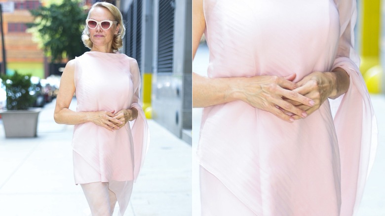 Pamela Anderson porte des lunettes de soleil blanches, une robe rose et des ongles en savon.
