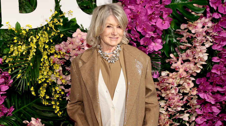 Martha Stewart posant lors d'un événement en 2026, vêtue d'une tenue beige et blanche avec un collier tendance.