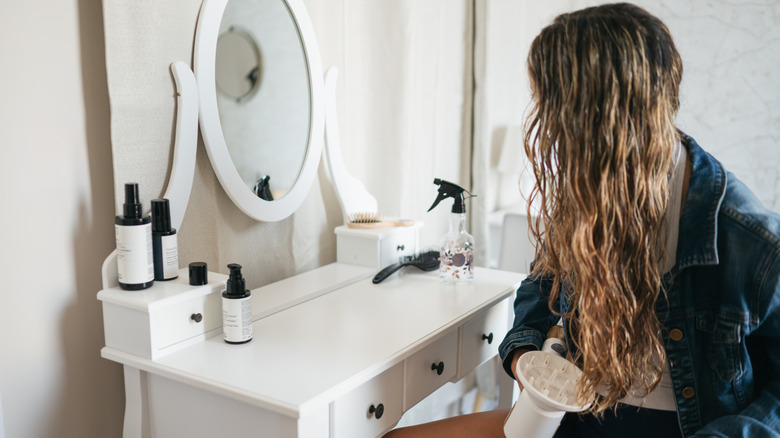 Une femme utilisant un sèche-cheveux sur ses boucles