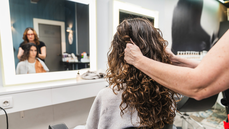 Une femme aux boucles irlandaises se fait couper les cheveux par un professionnel