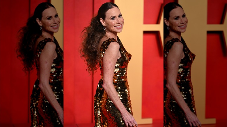 Minnie Driver porte une robe dorée étincelante avec ses cheveux en queue de cheval lissée et taquinée.