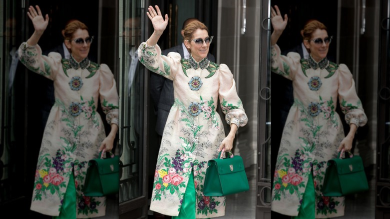 Céline Dion portant un manteau fleuri saluant les fans