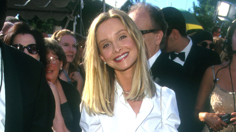 Calista Flockhart souriant lors d'un événement sur le tapis rouge avec des cheveux mi-longs portant une chemise blanche.