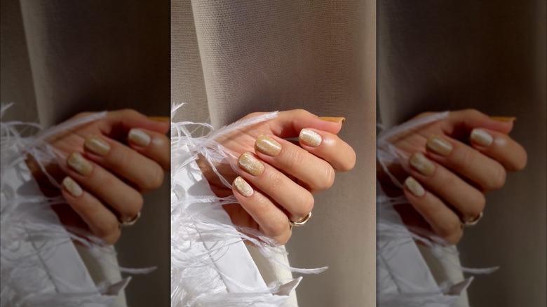 Une main avec des ongles en velours caramel