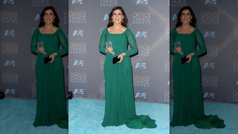 Mayim Bialik pose vêtue d'une robe vert émeraude