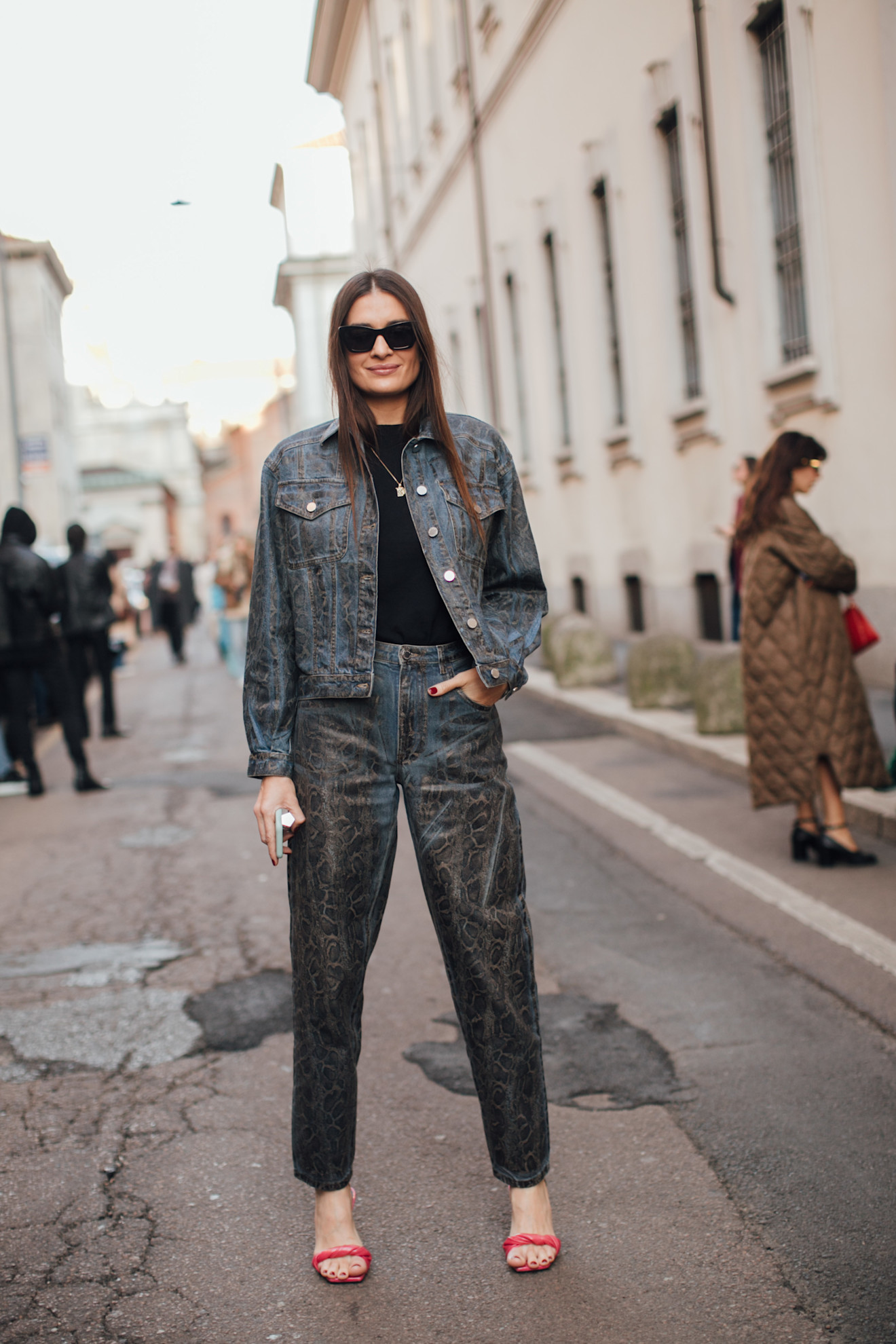Veste en jean deux pièces et jean avec pull en tricot à col rond et sandales rouges.
