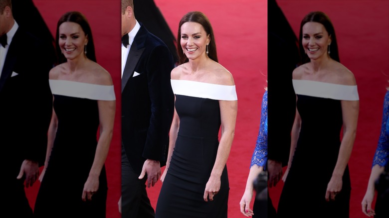 Kate Middleton sourit dans une robe monochrome à épaules dénudées