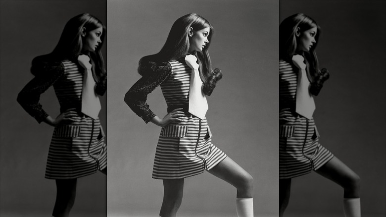 Jean Shrimpton pose avec une cravate surdimensionnée et une mini-robe rayée