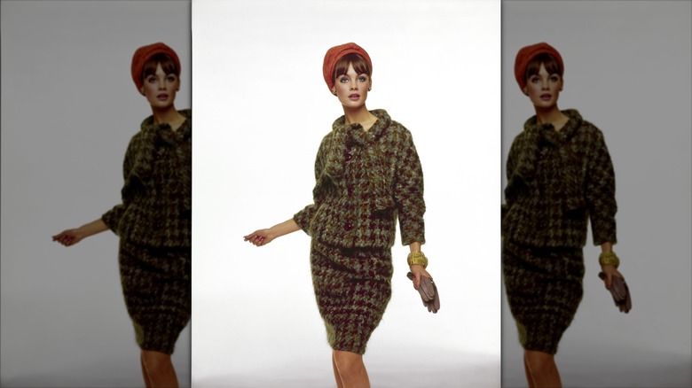 Jean Shrimpton portant un tailleur-jupe en tweed et un chapeau orange