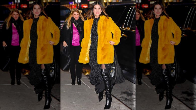 Sandra Bullock portant une robe à pois et une veste en fourrure tendance