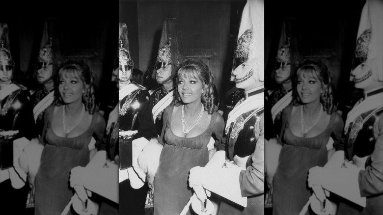 Ingrid Pitt sourit à côté des Royal Horse Guards, vêtue d'un ensemble de style antique