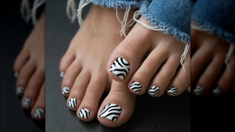 Une pédicure avec un vernis à ongles imprimé zèbre