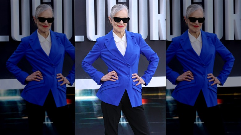 Elizabeth McGovern pose avec des lunettes de soleil noires et un blazer bleu vif