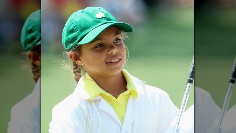 Sam Woods porte ses cheveux tressés sous une casquette verte des Masters avec une chemise jaune vif alors qu'elle assiste au tournoi des Masters 2015 en Géorgie.