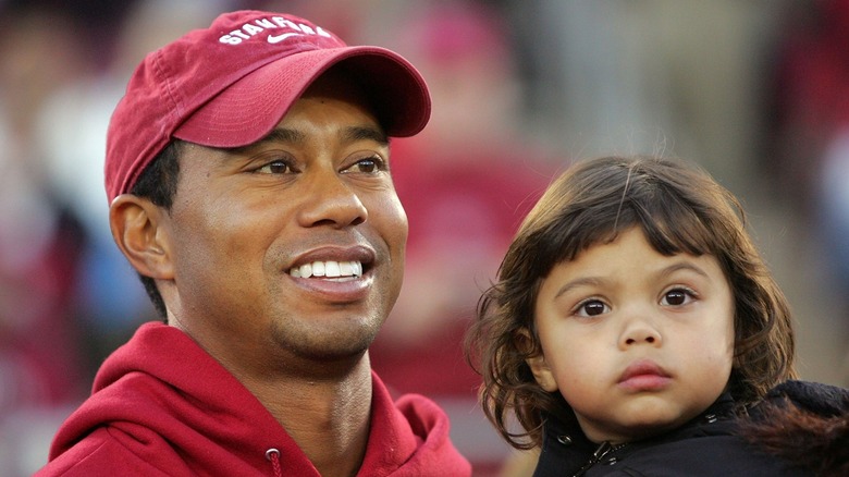 Tiger Woods tient sa petite fille Sam Woods dans une veste noire avec ses cheveux bruns détachés alors qu'elle assistait à un match de football de Stanford en 2009.