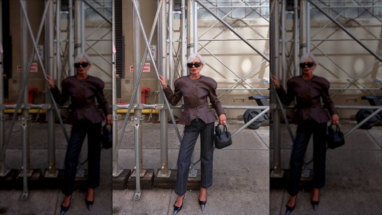 Grece Ghanem portant un blazer à épaulettes, des lunettes de soleil audacieuses et des talons pointus