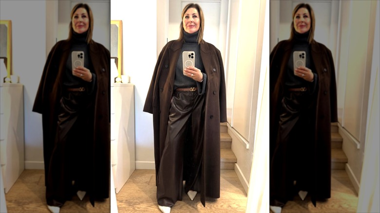 Fifi Milne porte un pantalon large en cuir marron avec un long manteau