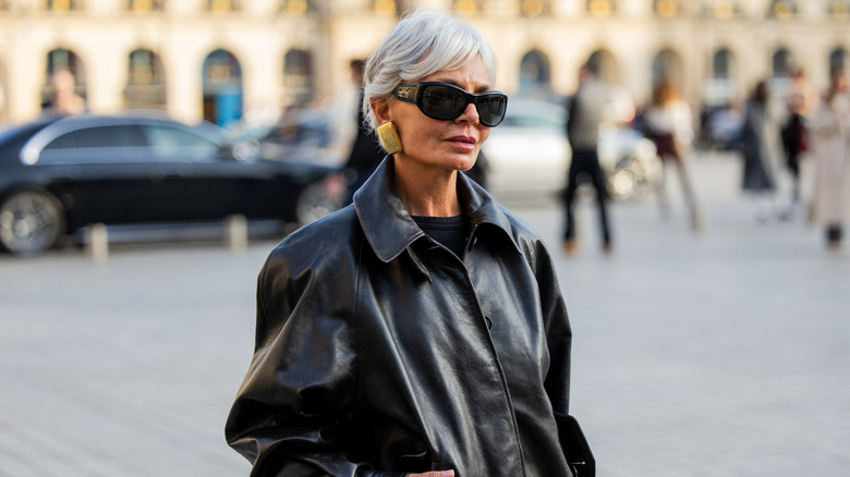 Grece Ghanem pose avec une veste en cuir noire et des lunettes de soleil noires