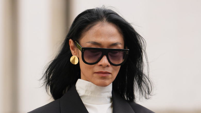 Une femme portant des boucles d'oreilles en forme de disque d'or.