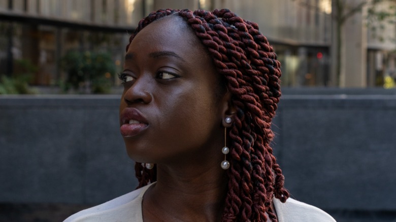 Une femme portant des boucles d'oreilles en perles.