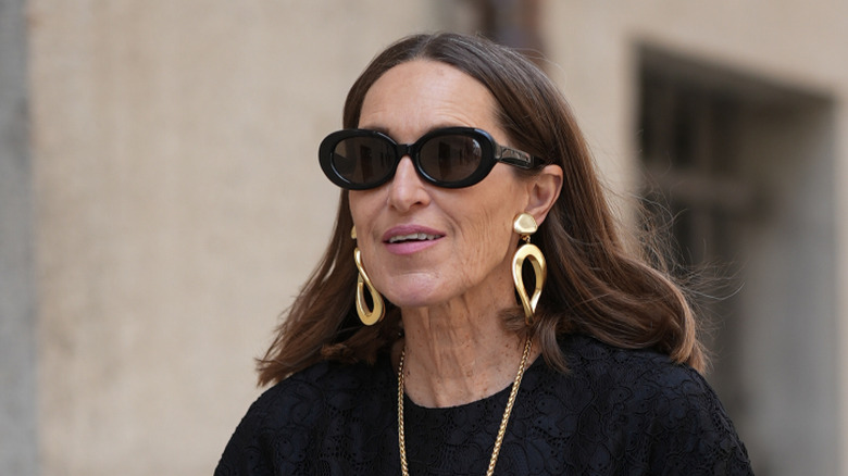 Une femme portant une paire de boucles d'oreilles en or.