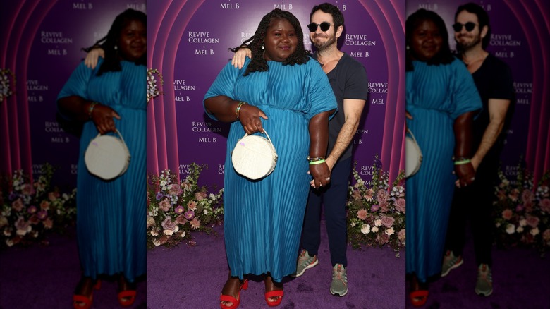 Gabourey Sidibe portant une robe bleue et des chaussures rouges pose aux côtés de son mari Brandon Frankel