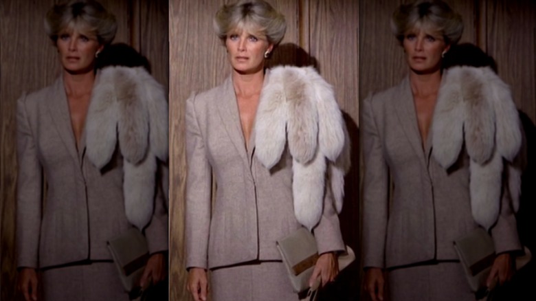 Linda Evans photographiée dans le rôle de Krystle Carrington dans Dynasty portant un blazer, une jupe et un châle en fourrure