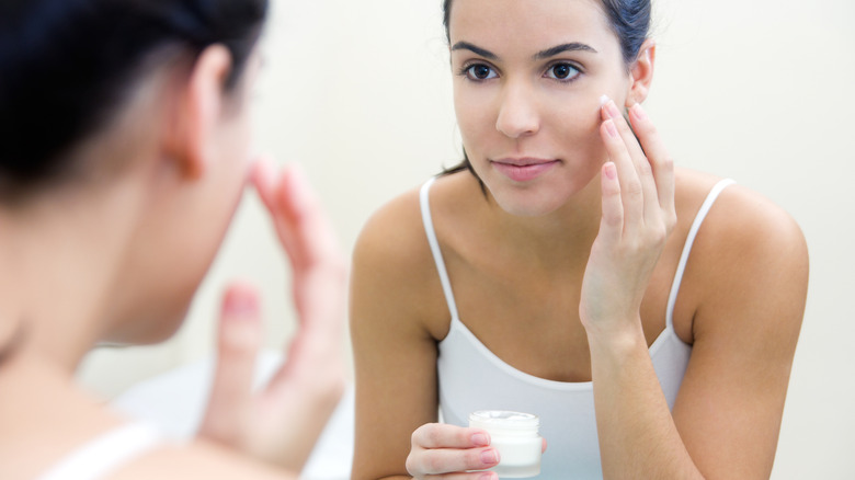 Femme appliquant de la crème sur son visage