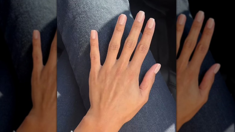 Femme aux ongles rose pâle