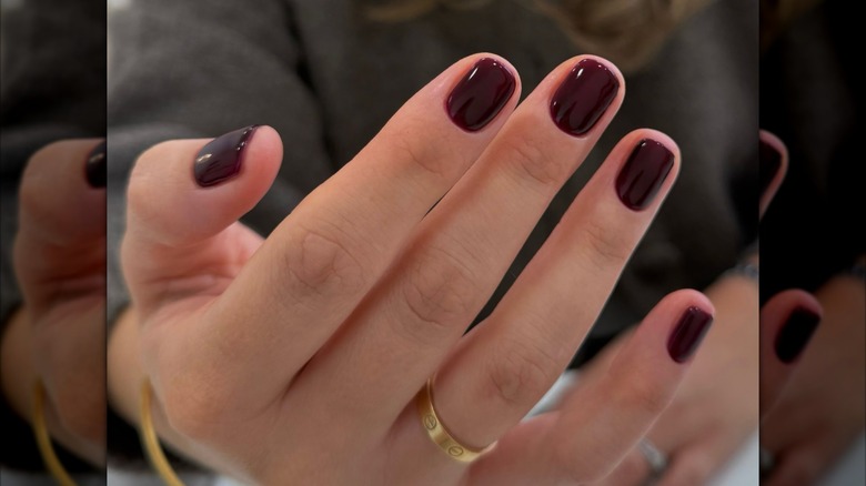 Femme aux ongles bordeaux