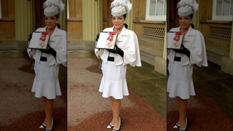 Joan Collins porte une robe blanche
